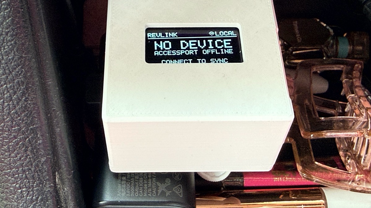 Close-up of the printed case showing a small OLED reading REVLINK, NO DEVICE, ACCESSPORT OFFLINE, CONNECT TO SYNC.
